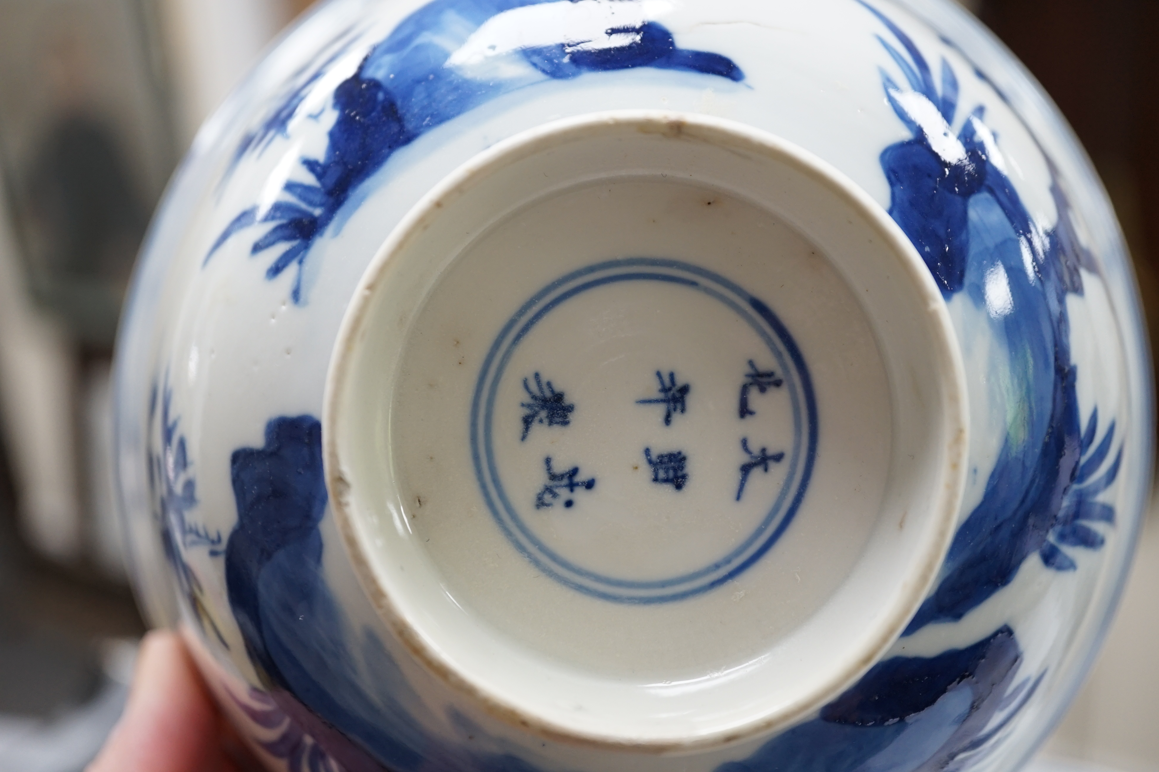 A near pair of Chinese blue and white ‘birds’ bowls, Kangxi period, one bowl restored